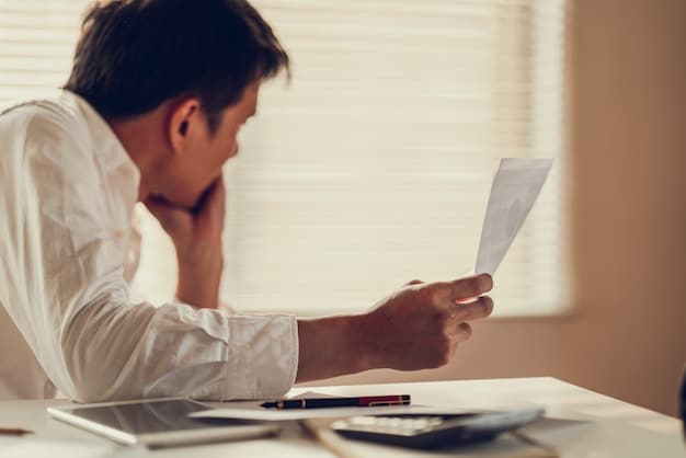 A person looking stressed and overwhelmed while reviewing their bank statements and credit reports, indicating the emotional and financial strain caused by identity theft.
