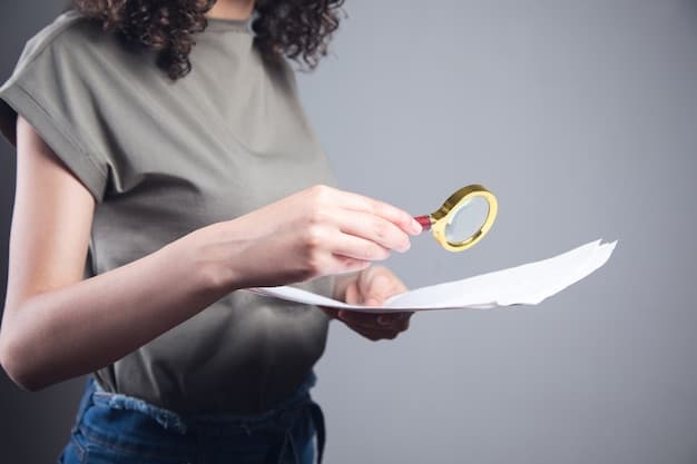 A close-up of a hand holding a magnifying glass over a document titled 